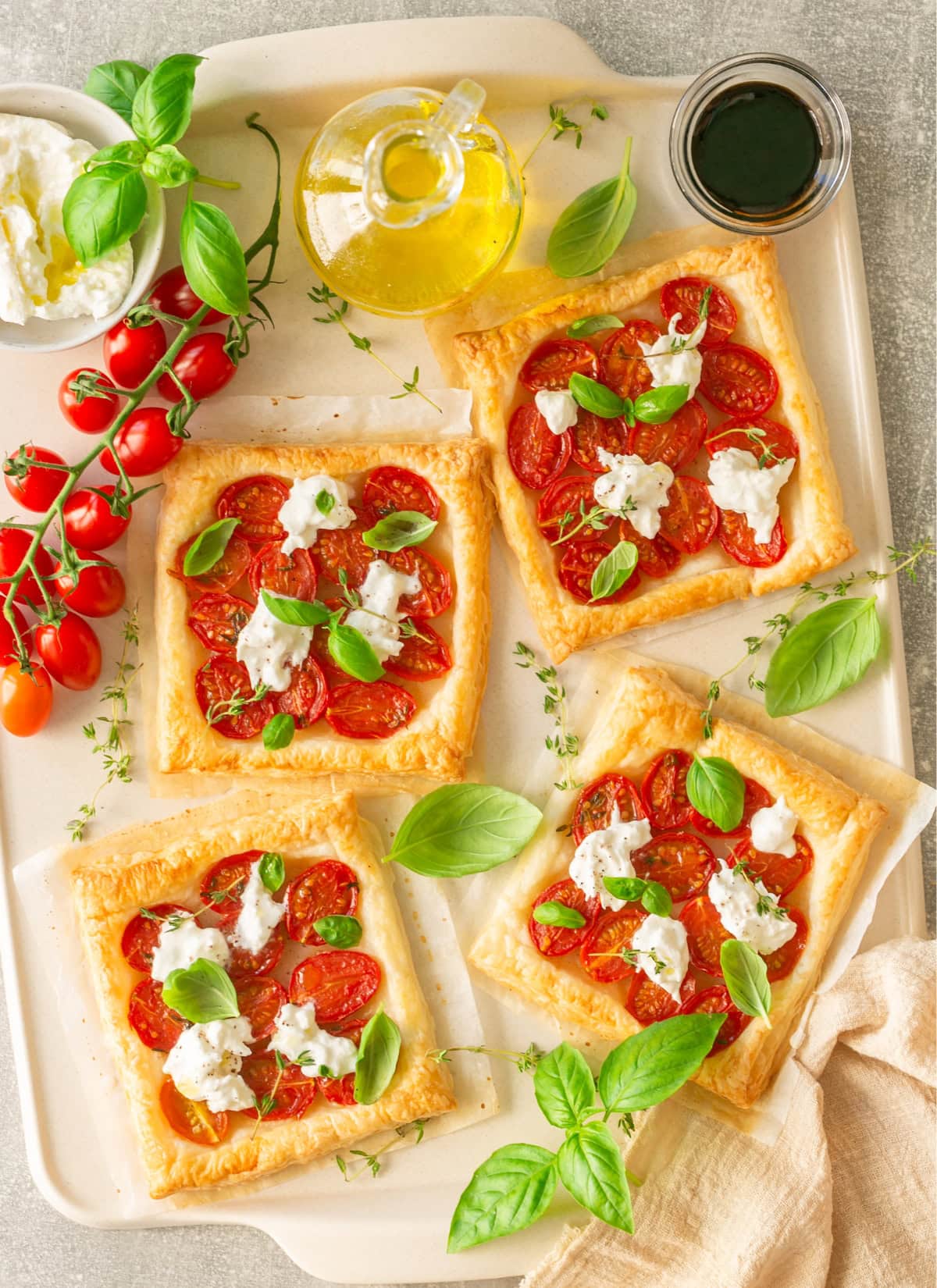 Caprese tarts with tomatoes, burrata cheese and basil leaves.