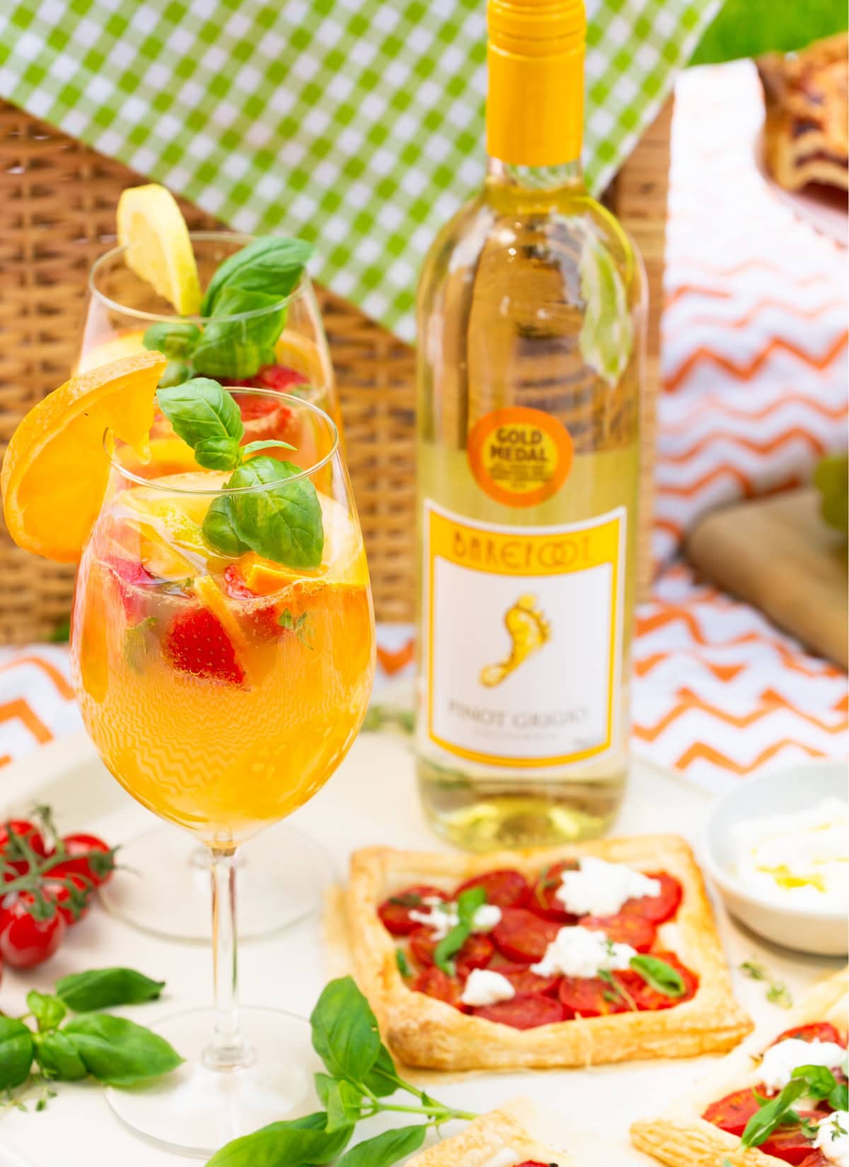 white sangria wine cocktail served with caprese tarts in a picnic setting.